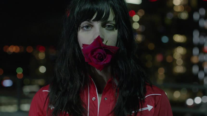 A man holds a rose in her mouth