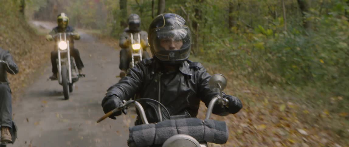 Motorcyclists ride in a forest