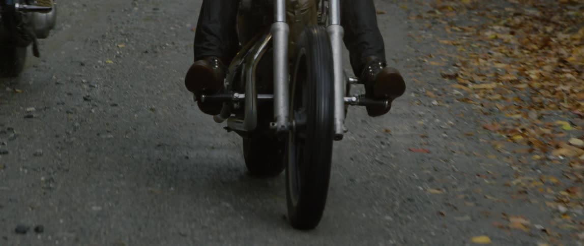 Two men riding motorcycles on a street
