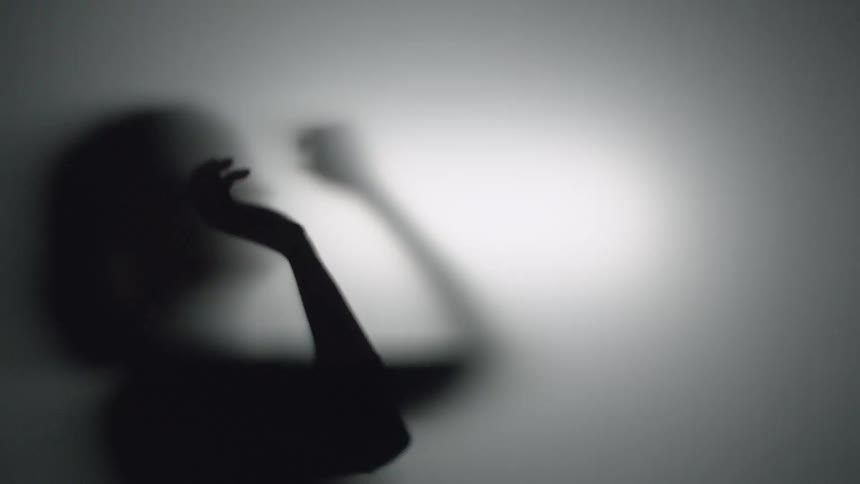 A woman dances against the light