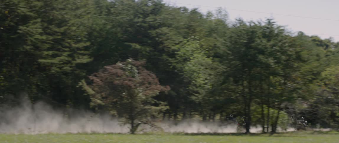 Motorcyclists ride on a dirt road