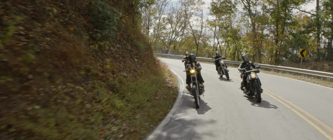 Motorcyclists ride on a mountain road