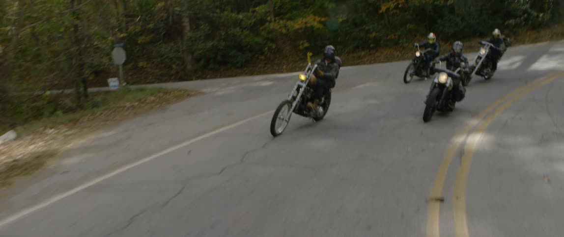Motorcyclists ride down a mountain road