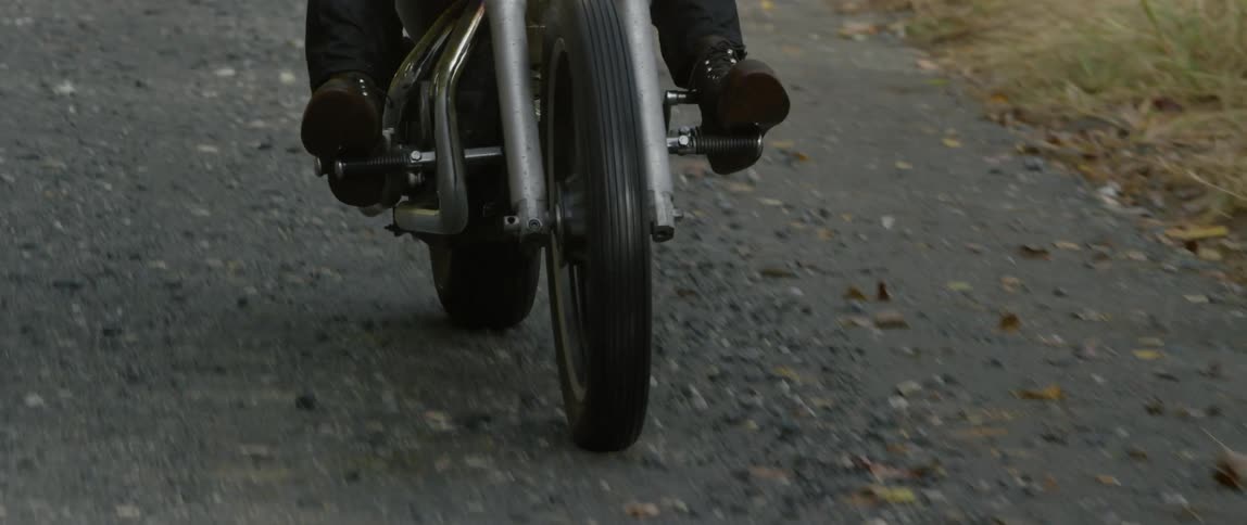 People travel by motorcycle on a winding country road