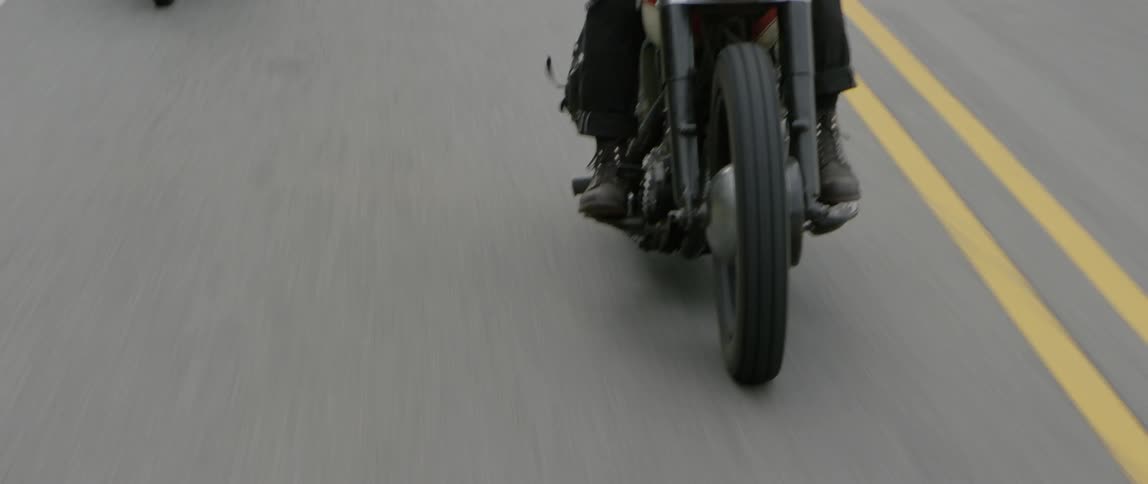 A motorcyclist rides on a paved road