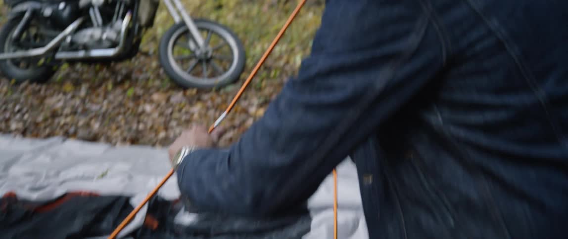 Man builds a tent in the woods