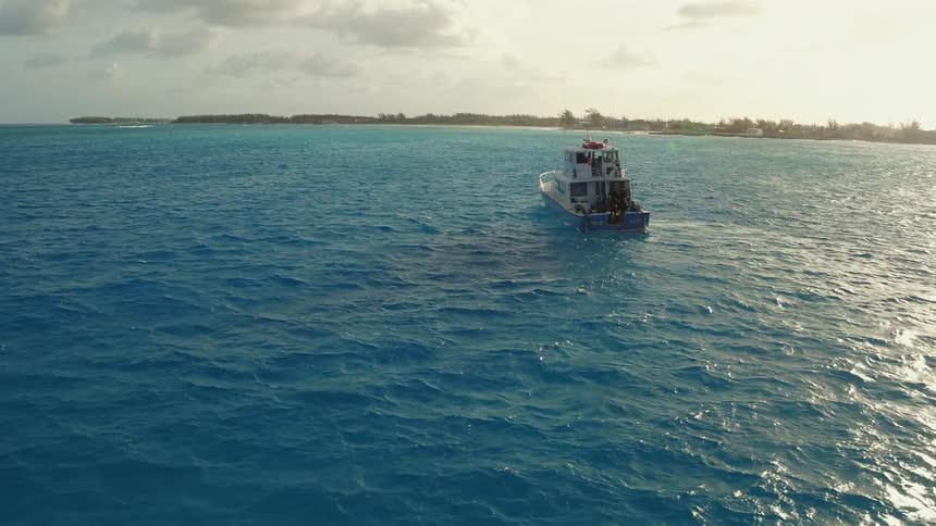 A boat travels on clear blue water