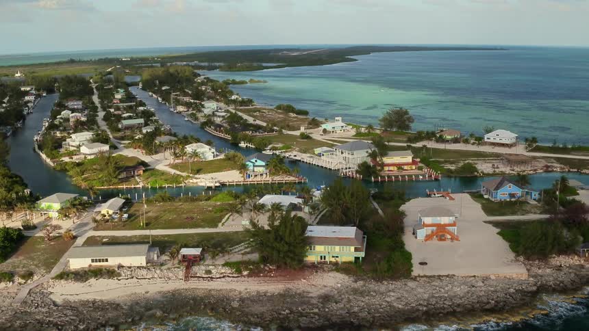 Ocean waves are lapping the shores of an island community during the day