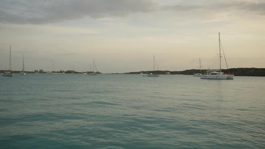 Several boats in a large body of water on a grey cloudy day