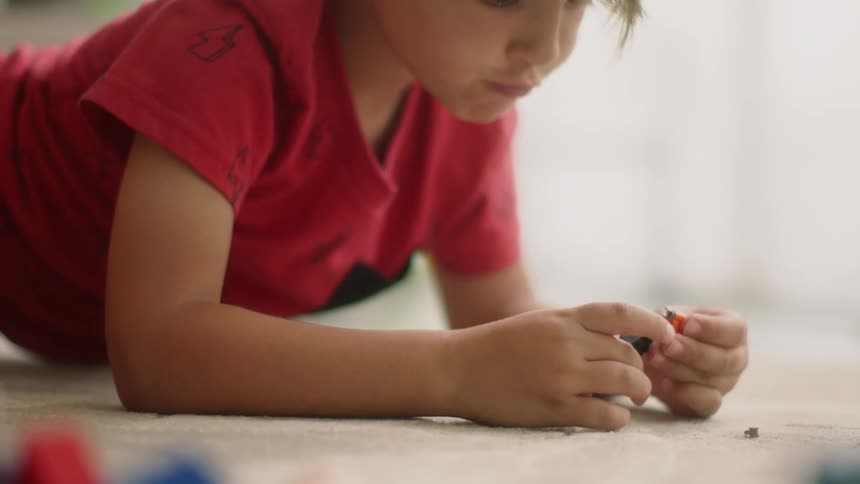 A young boy plays with toys indoors