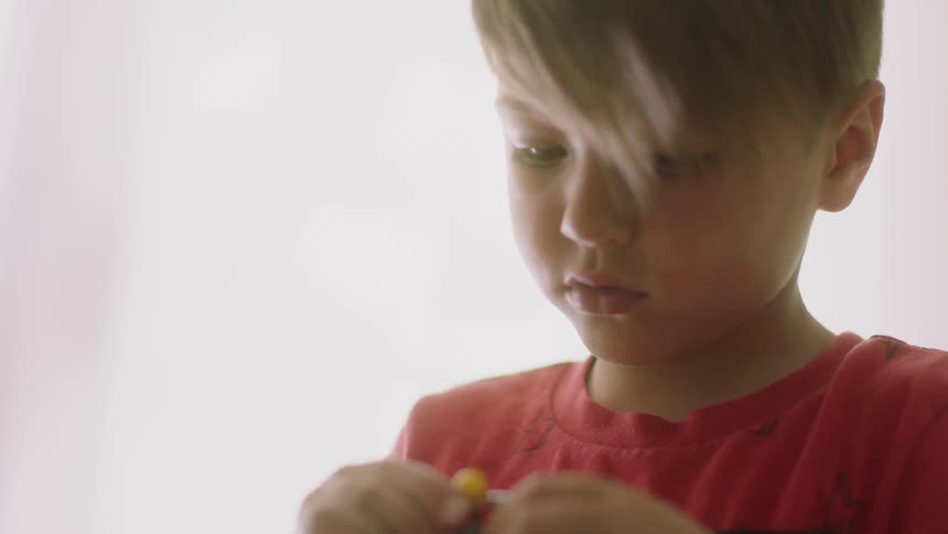 A young boy plays with toys indoors
