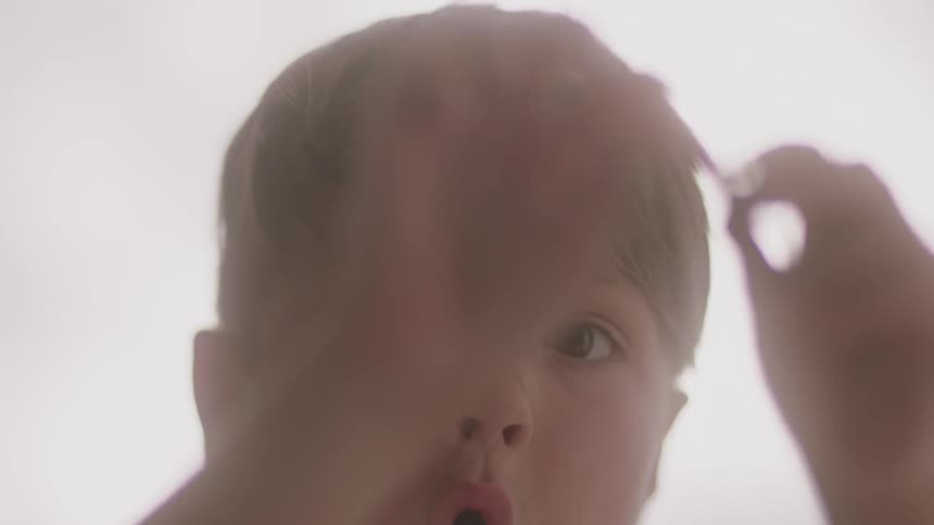 A young boy plays with a toy indoors