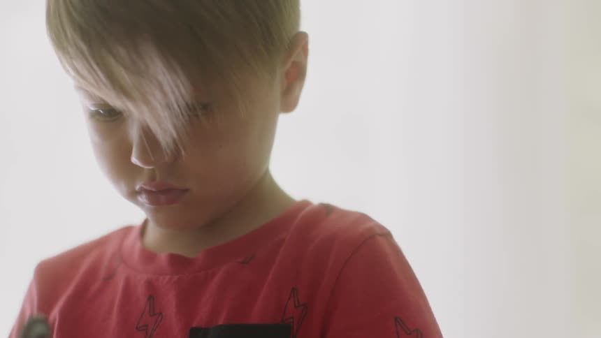 A young boy holds something in his hands