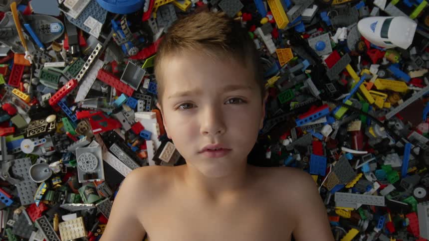 A young boy lies on a pile of building blocks