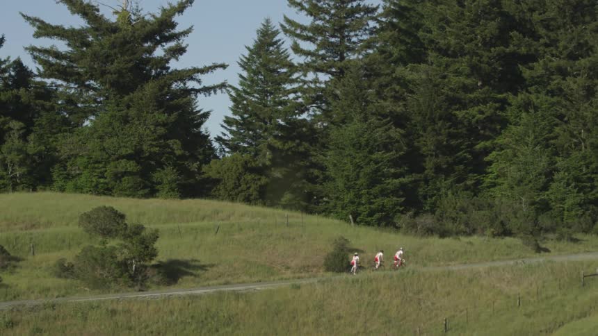 Bicyclists pedal through a grassy area