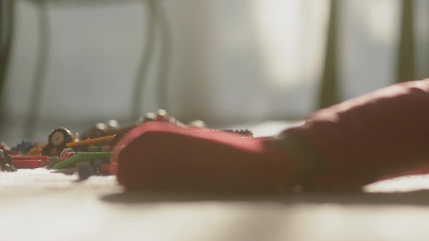 A child lies on the floor with toys