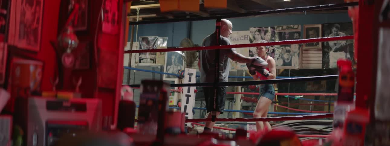 A woman practices boxing with a trainer