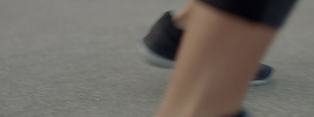 An athlete's legs and feet as they move around on the asphalt