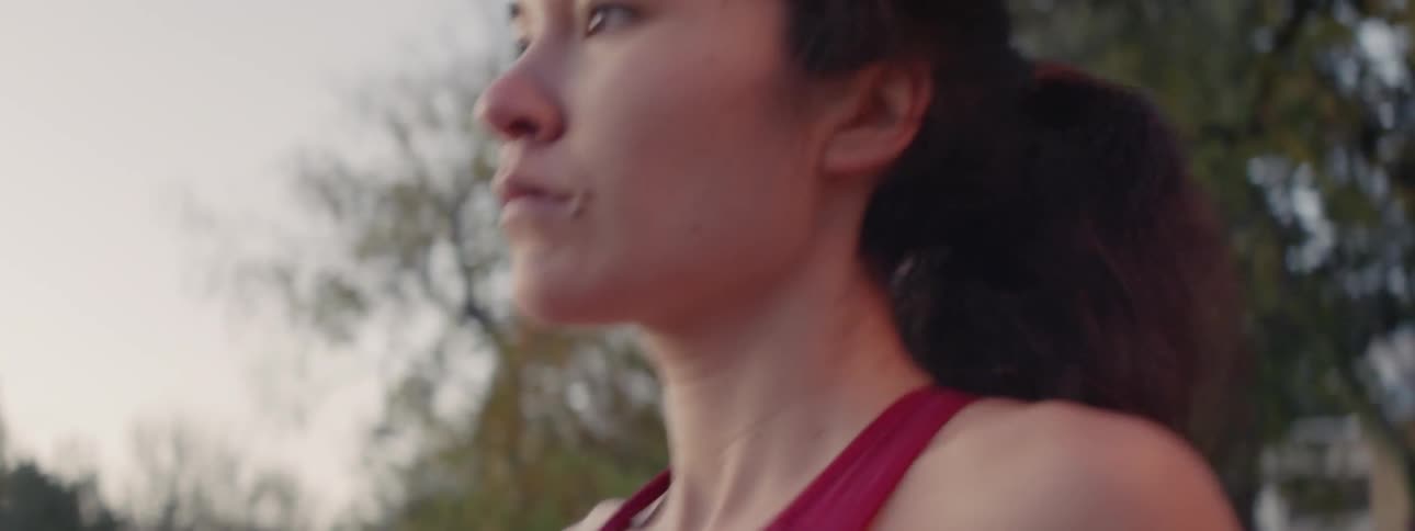 A woman is jogging outside on a cloudy day