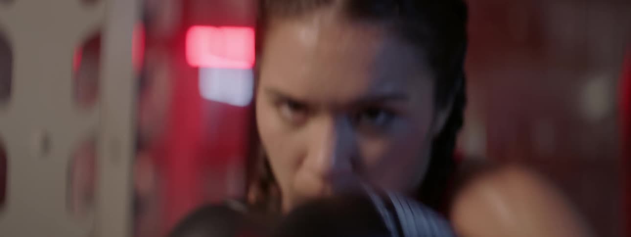 A woman sweats while boxing in a gym