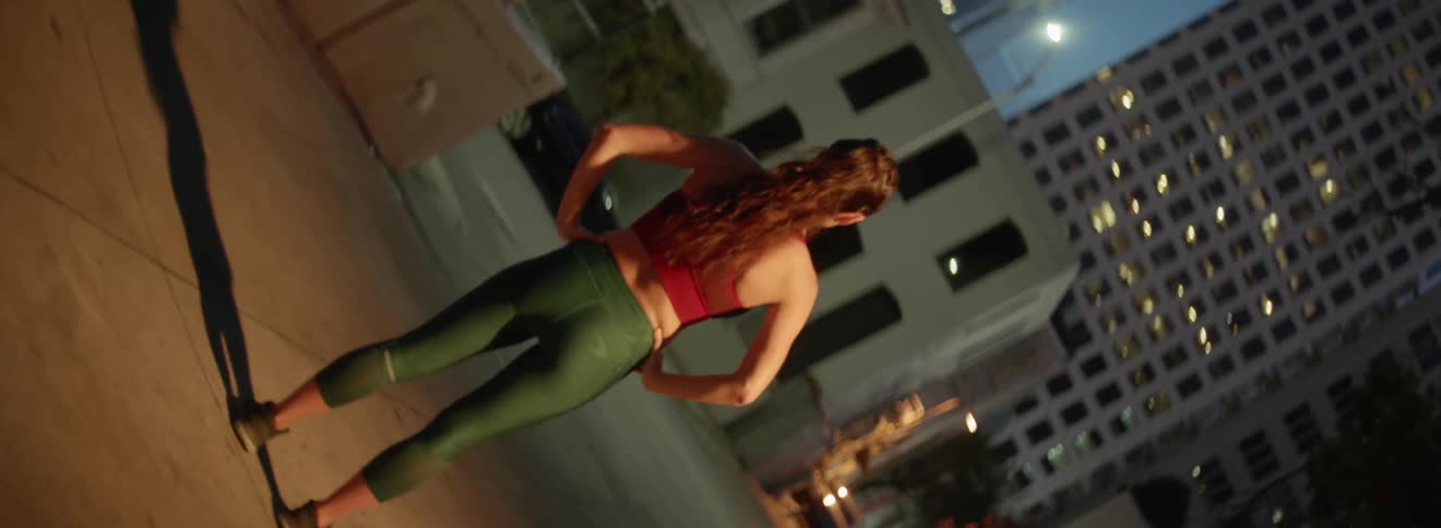 A woman standing on a sidewalk in a city