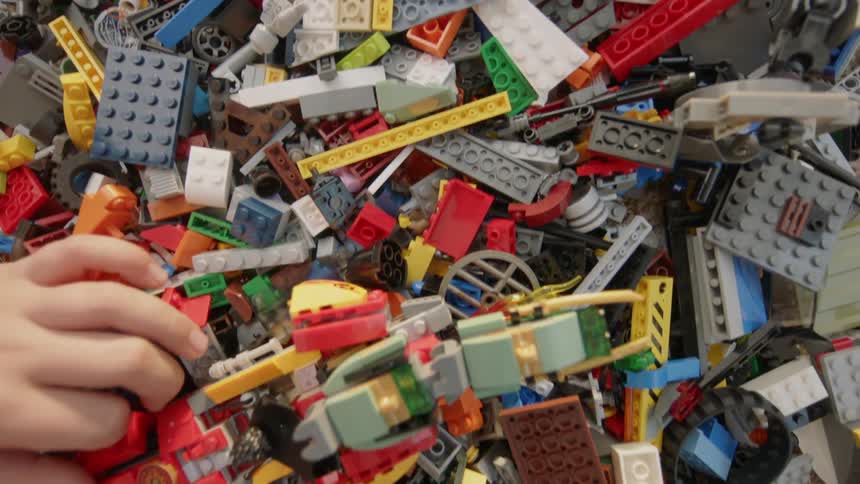 A child plays with a pile of toy building blocks