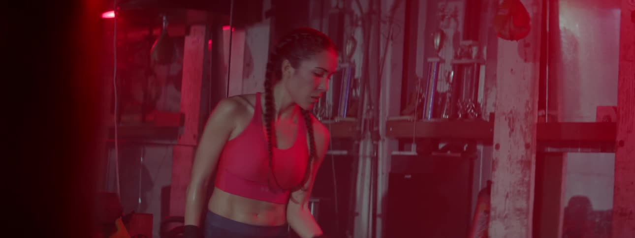 A woman lifts weights in a gym