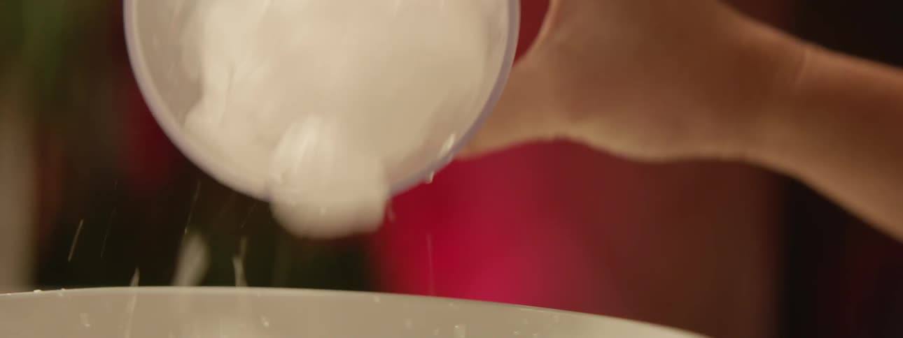 A woman pours ice into a bowl