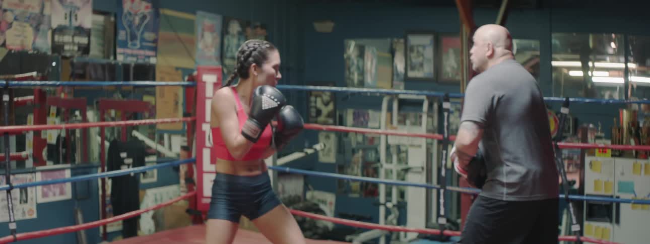 A man coaches a boxer in a boxing ring