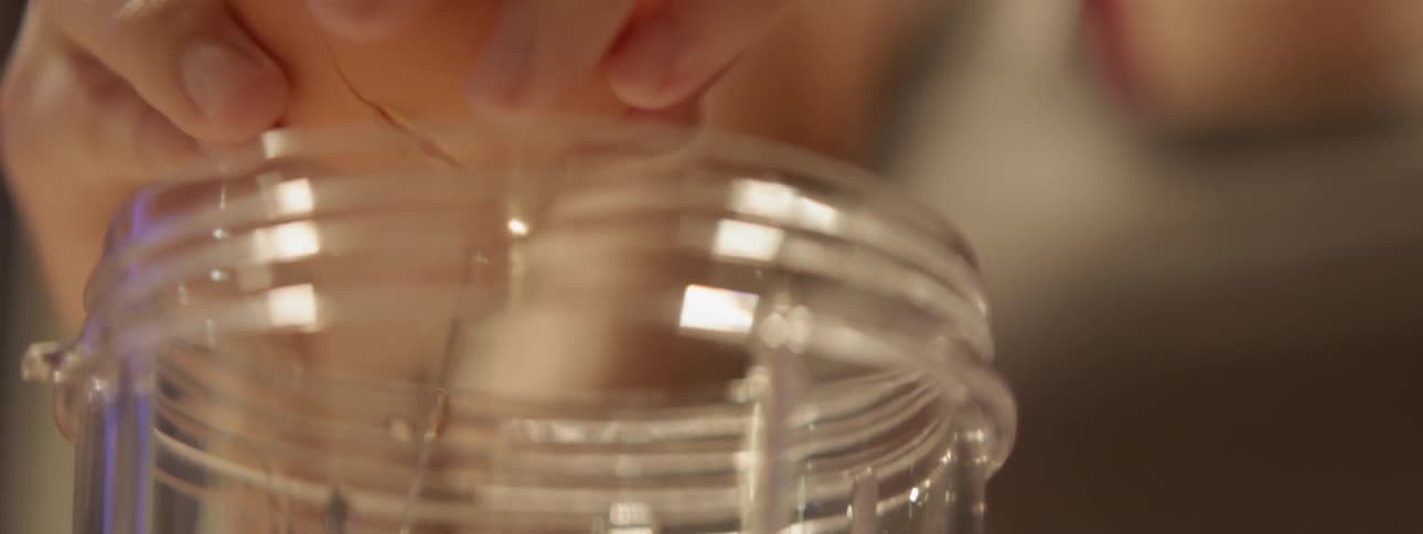 A person cracks an egg into a cup