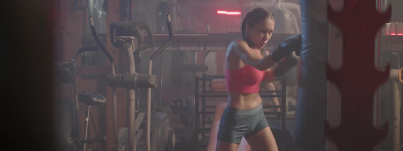 A woman hits a punching bag in a gym