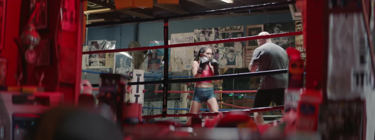 Two people are shadowboxing in the ring nearby