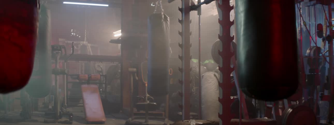 Heavy bag slowly swinging as lights get turned off in a gym