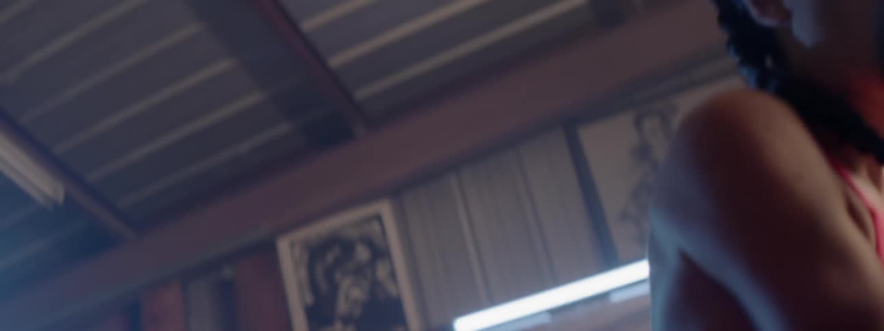 A female boxer is punching a bag in a gym