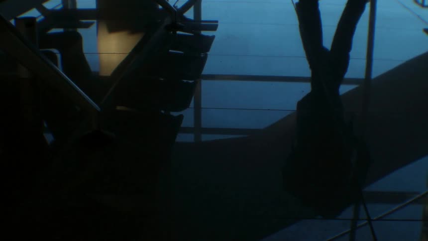 A person walks on reflective tile