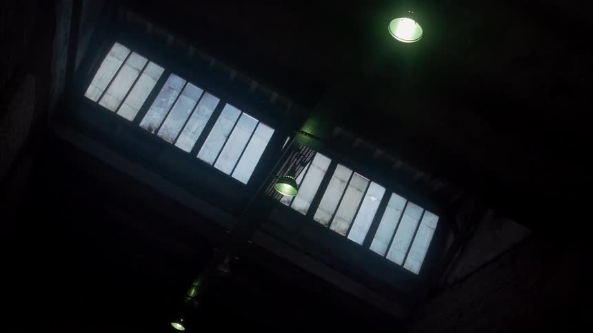 Lights hang from the ceiling of a warehouse