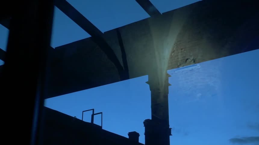 A flashlight shines on a building structure at night