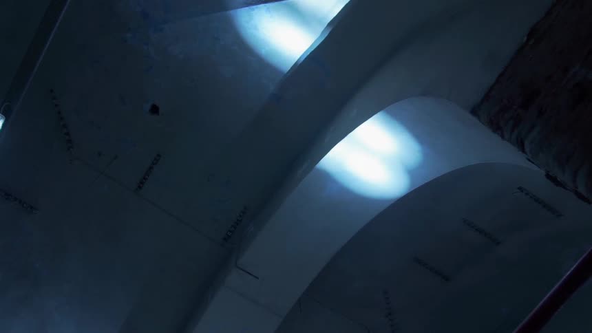 Light beams shine on a ceiling