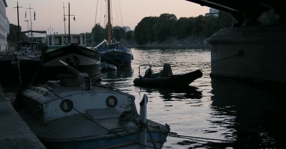 Boats float in a marina at sunrise