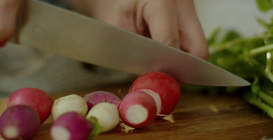 A woman slices beets on a cutting board