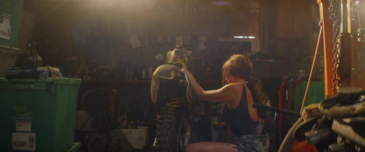A woman repairs a motorcycle in a garage