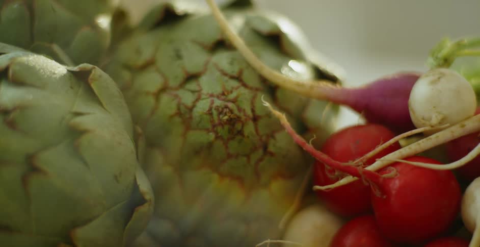Green and red vegetables are displayed on a countertop