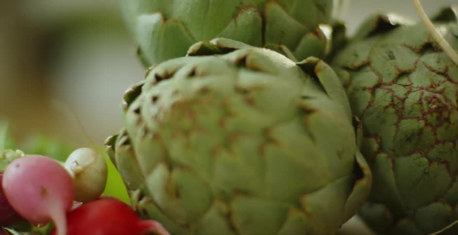 The table is full of radish and artichokes