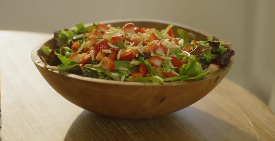 A wooden salad bowl is sitting on the table