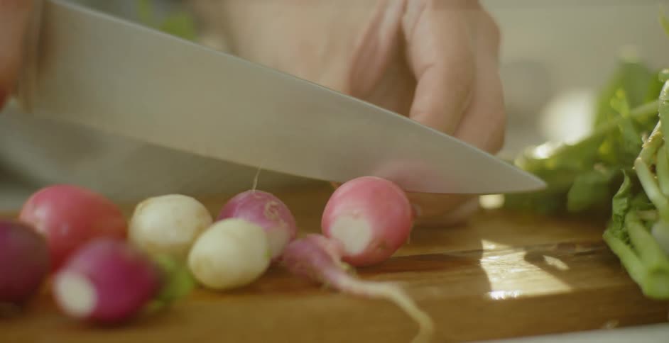 A chef is chopping radishes