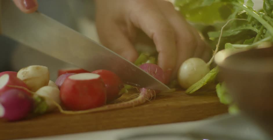 A woman slices beets on a cutting board