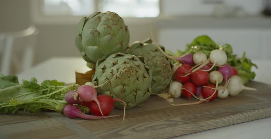 Green and red vegetables are displayed on a countertop