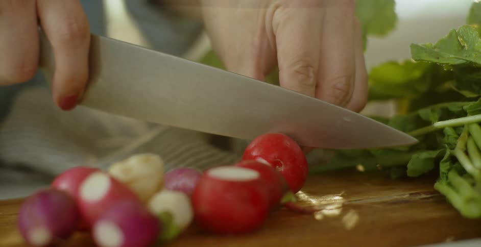 A person is slicing up some radishes