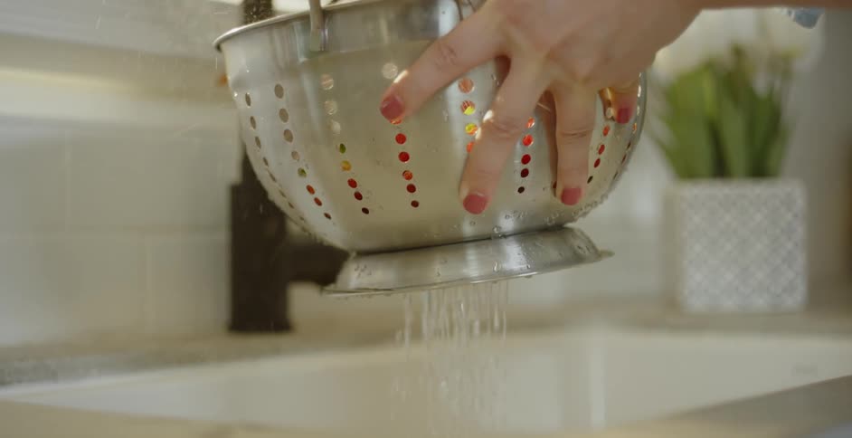 Produce is washed in a metal colander
