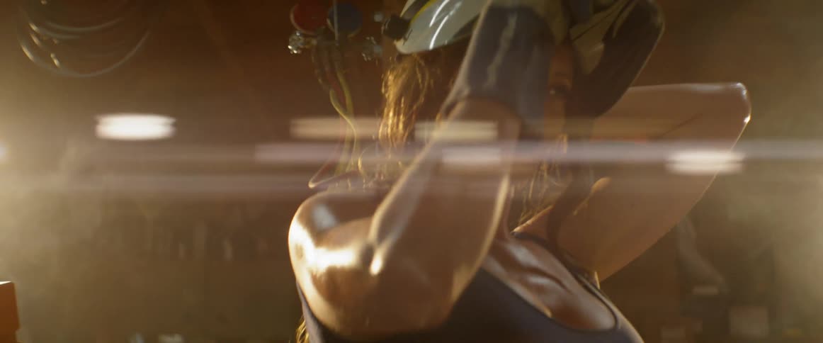 A woman sweats while wearing a welding mask